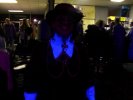 Kendra in Cavalier garb stands underneath a black light in a bowling alley, thus creating the Glowing Collar and Cuffs of Doom!